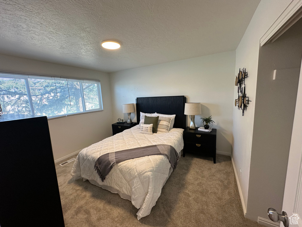 Bedroom with carpet and a textured ceiling