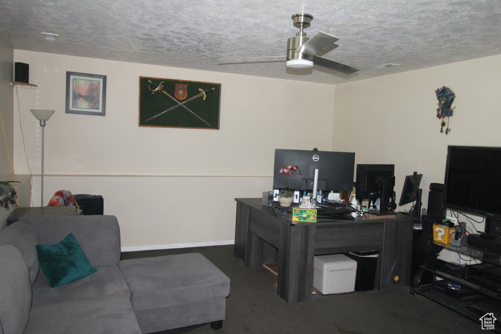Office space with a textured ceiling, a ceiling fan, and carpet flooring