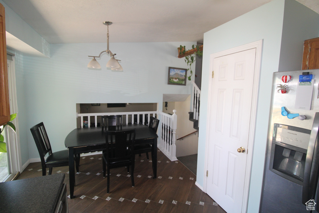 Dining room featuring a chandelier, dark wood-style floors, and stairs