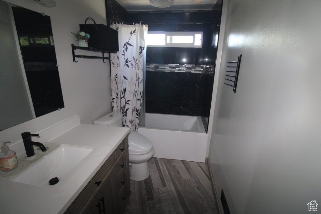 Full bath featuring vanity, shower / bath combination with curtain, and wood finished floors