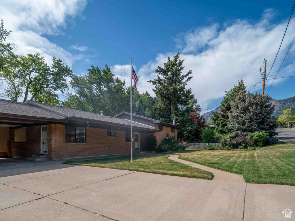 View of front of home featuring brick siding, a front lawn, and entry steps