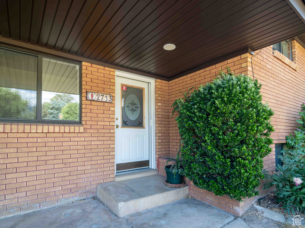 View of exterior entry with brick siding