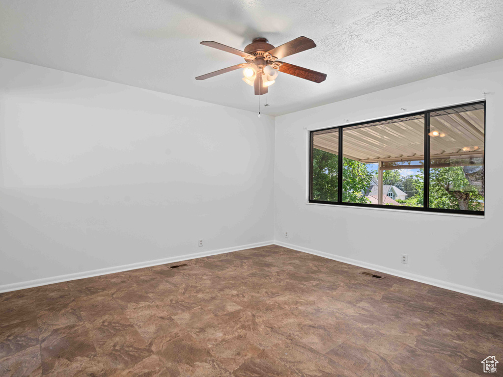 Unfurnished room featuring baseboards and a ceiling fan
