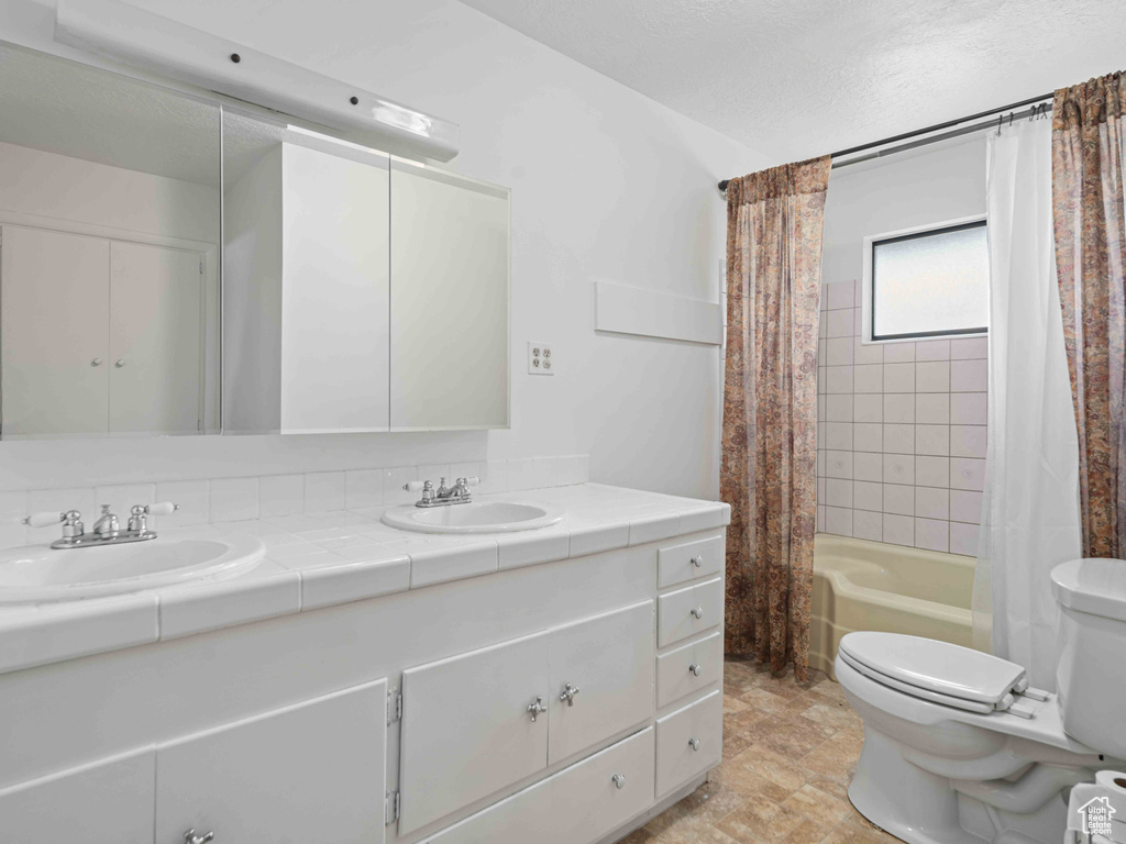 Bathroom with double vanity and shower / bathtub combination with curtain