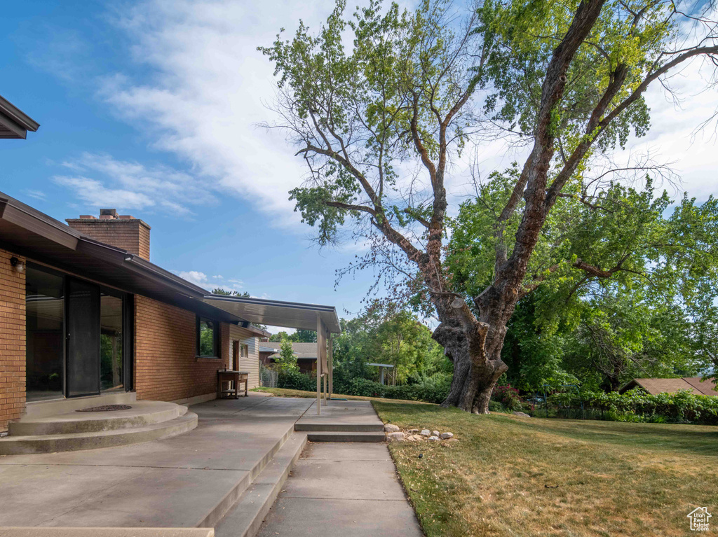 View of green lawn featuring a patio
