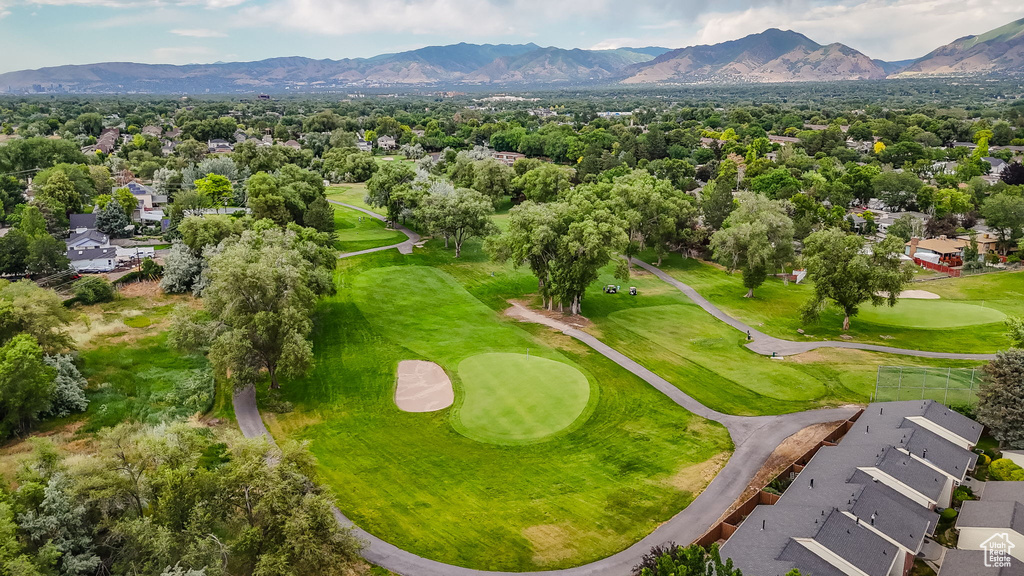 Aerial view of residential area featuring a mountain backdrop and a golf course