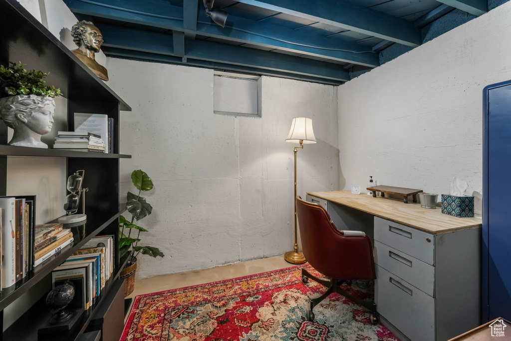 Office with concrete floors and beamed ceiling