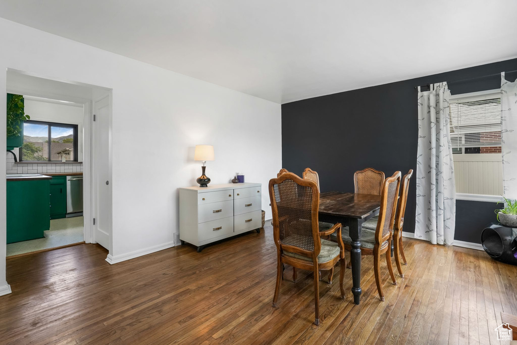 Dining area with dark wood-type flooring and baseboards
