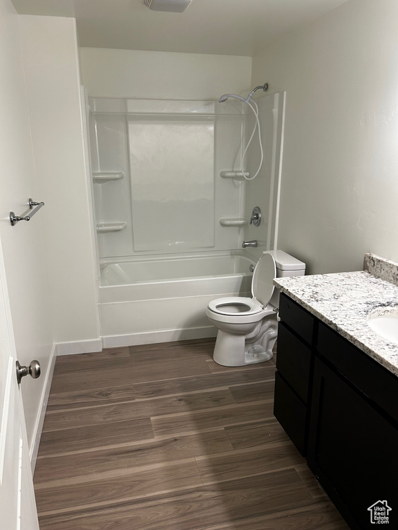 Full bath featuring vanity, wood finished floors, and shower / bath combination