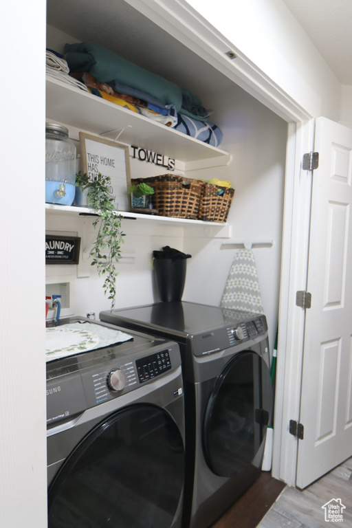 Washroom with separate washer and dryer and wood finished floors