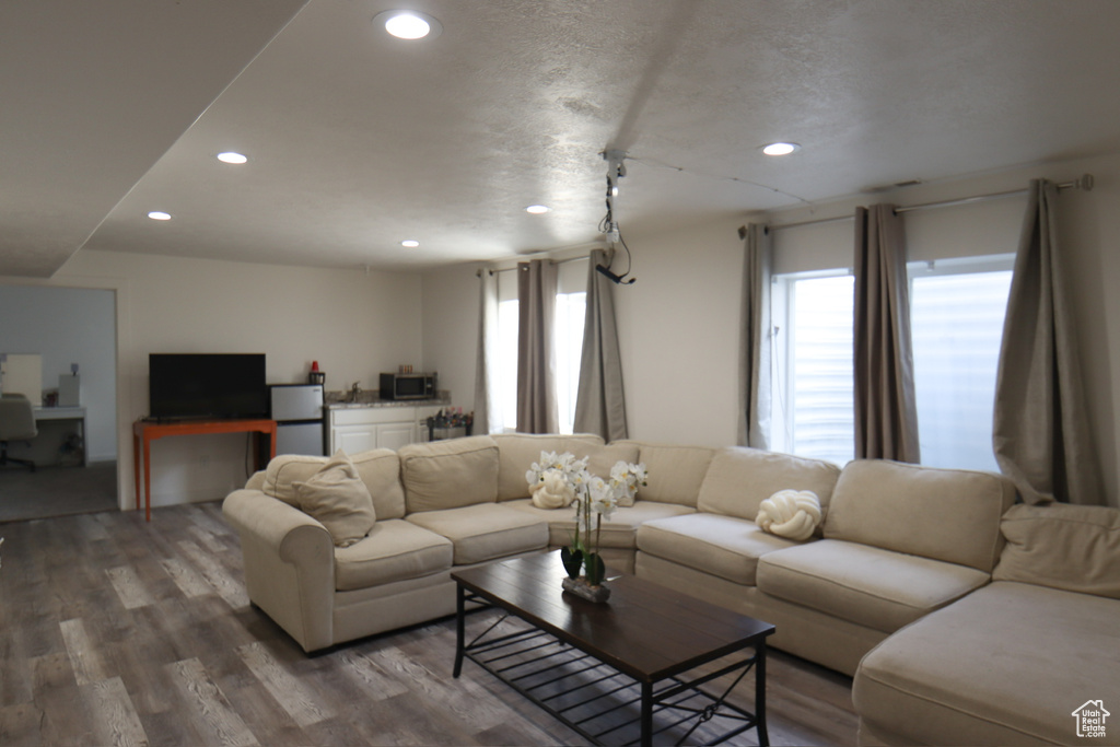 Living area with plenty of natural light, recessed lighting, wood finished floors, and an office area