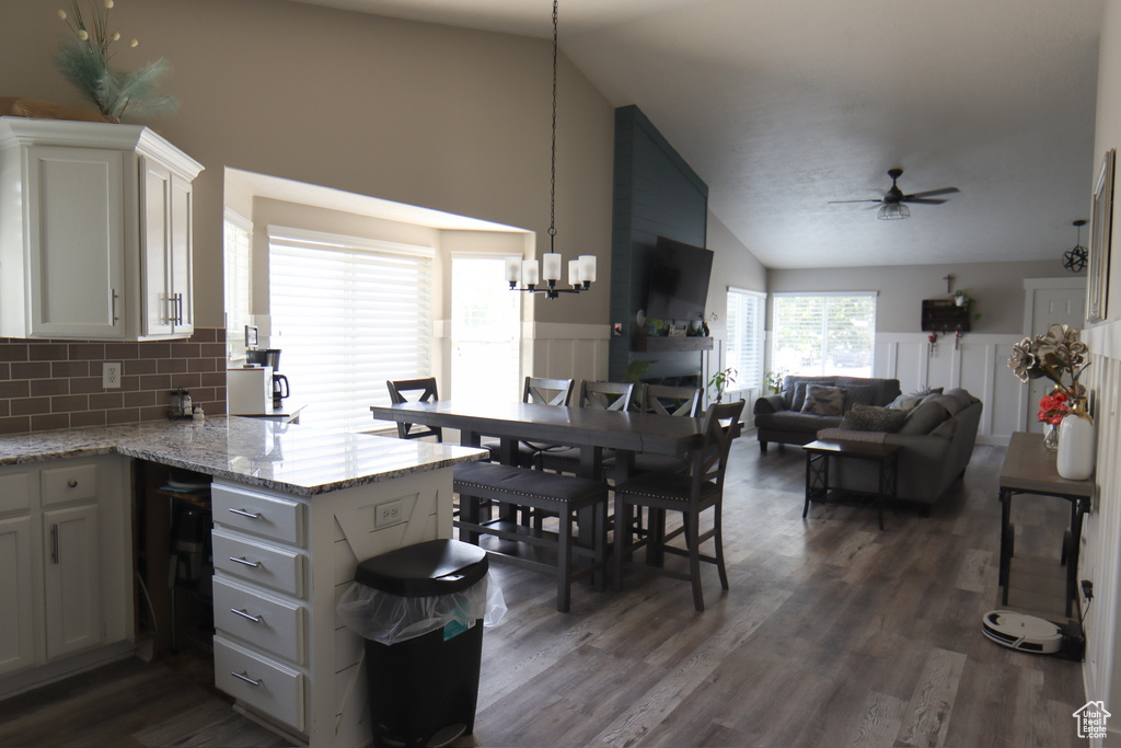Kitchen featuring ceiling fan, a chandelier, tasteful backsplash, a peninsula, and dark wood-style floors