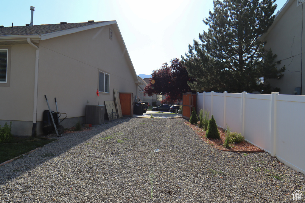 View of side of home with stucco siding and a shingled roof
