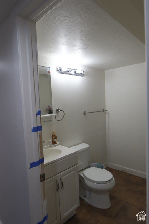 Half bathroom featuring vanity and a textured ceiling