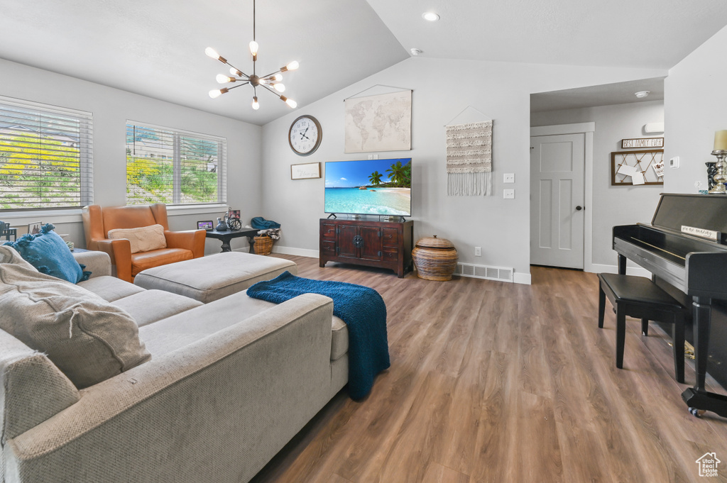 Living area with a chandelier, wood finished floors, lofted ceiling, and recessed lighting