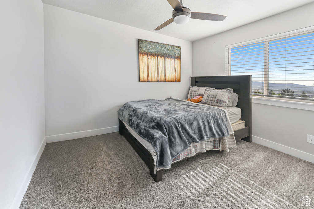 Carpeted bedroom with baseboards and ceiling fan