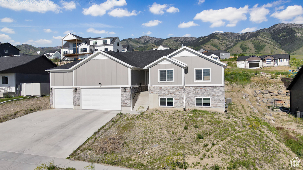 View of front of house with stone siding, a mountain view, and board and batten siding