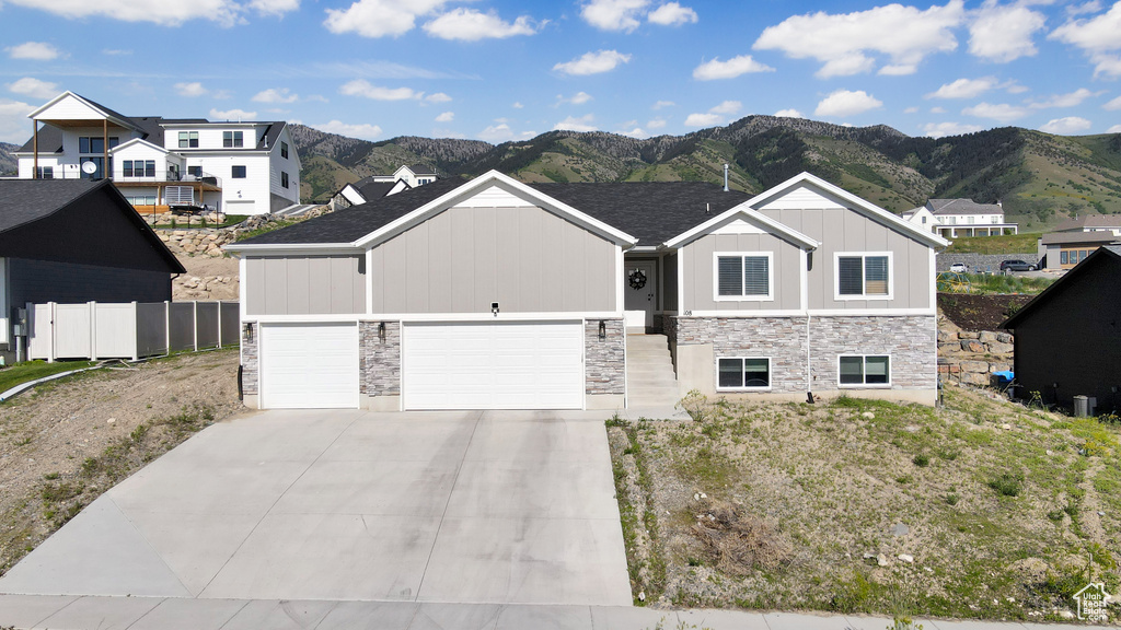 View of front of property with a mountain view, board and batten siding, and stone siding