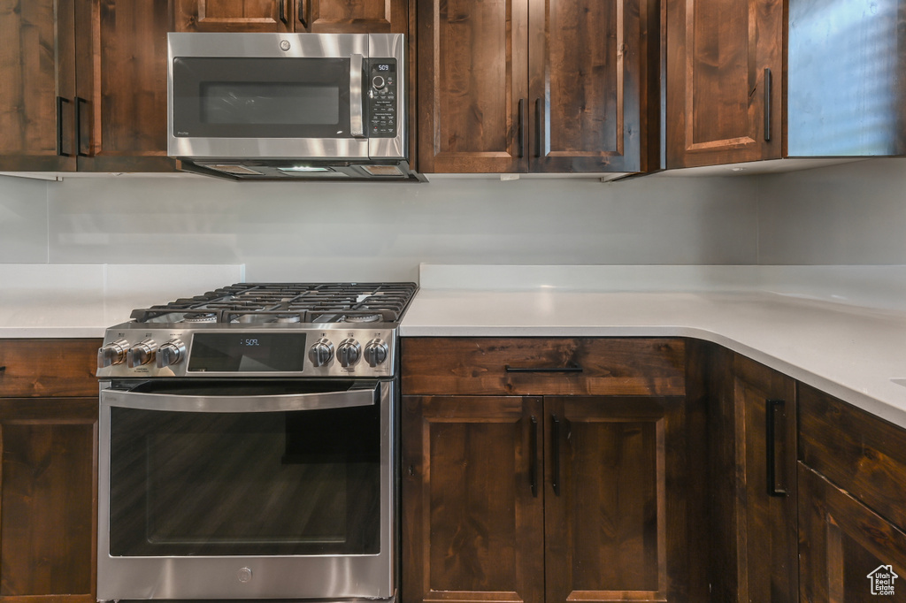 Kitchen featuring appliances with stainless steel finishes, light countertops, and dark brown cabinetry