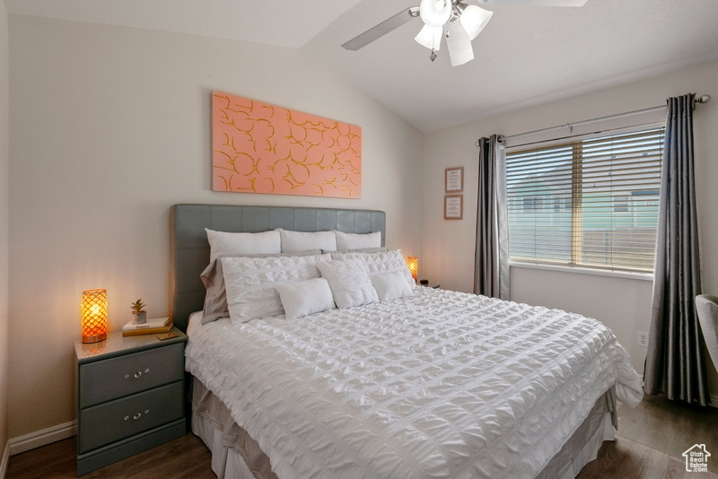 Bedroom featuring dark wood-style flooring, lofted ceiling, and ceiling fan
