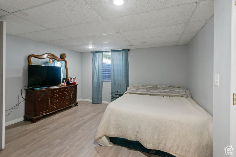 Bedroom featuring light wood finished floors and a paneled ceiling