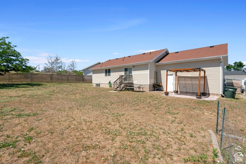 Rear view of property featuring a fenced backyard and a patio area