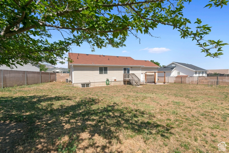 Rear view of house with a fenced backyard