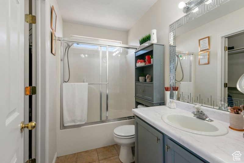 Full bath with vanity, shower / bath combination with glass door, and tile patterned floors