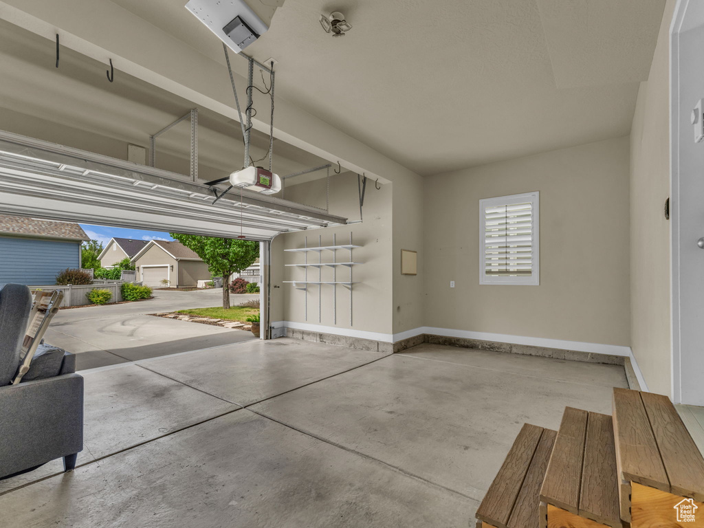 Garage with a garage door opener and baseboards