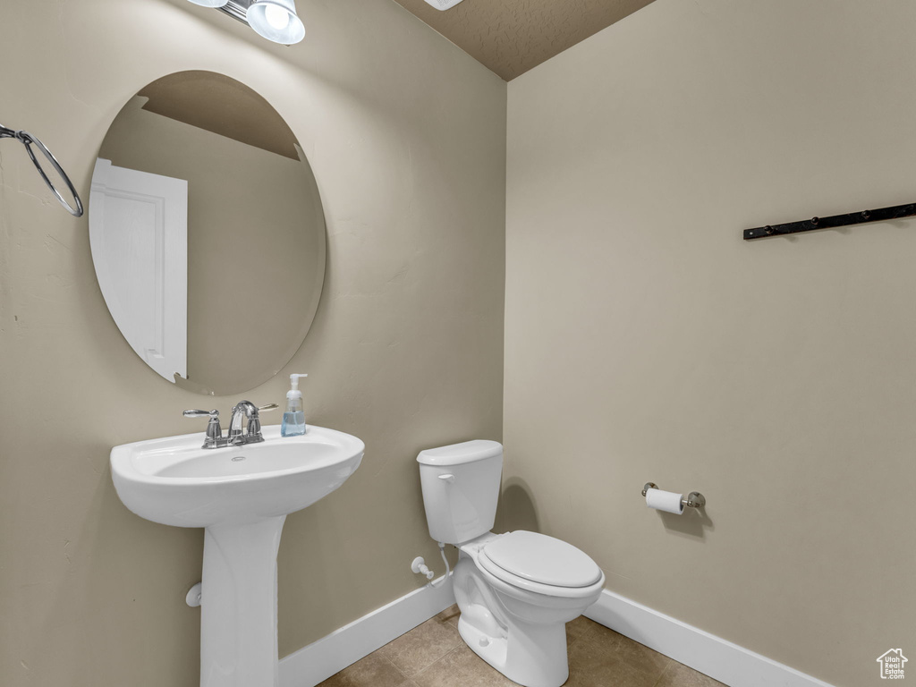 Half bathroom featuring baseboards and tile patterned flooring