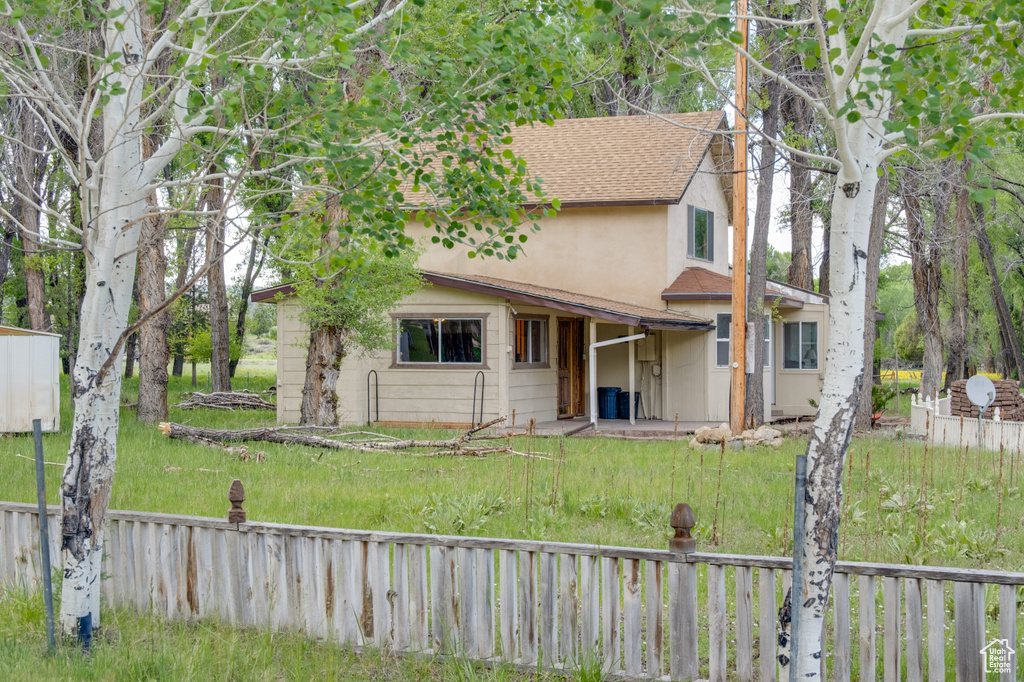 View of front of home with stucco siding and a shingled roof