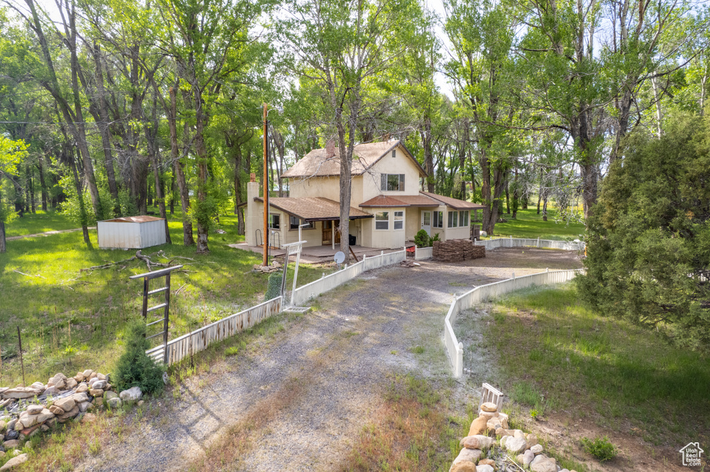 View of front of property with a shed and stucco siding