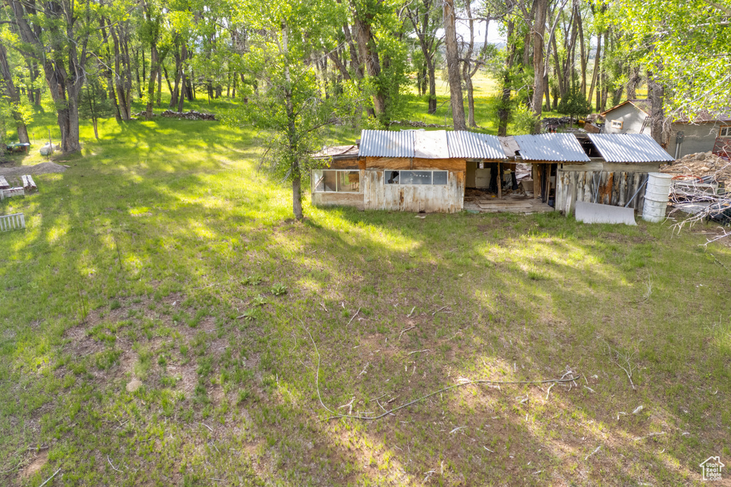 View of front of house featuring a front lawn and a metal roof