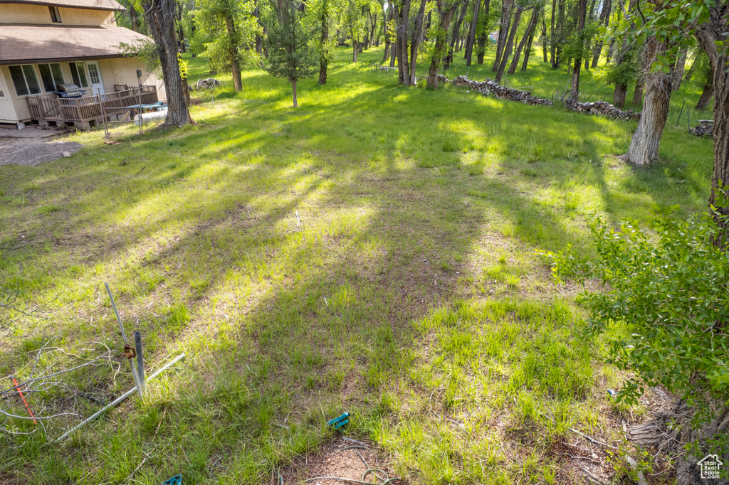 View of grassy yard with a deck