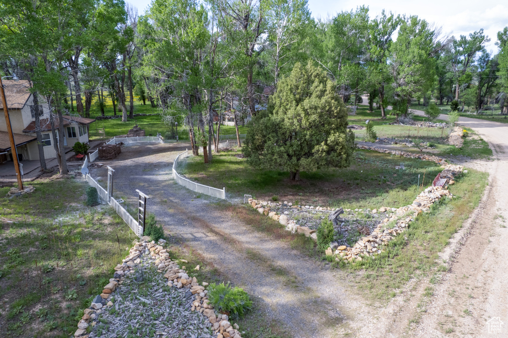 View of dirt / gravel road featuring view of wooded area