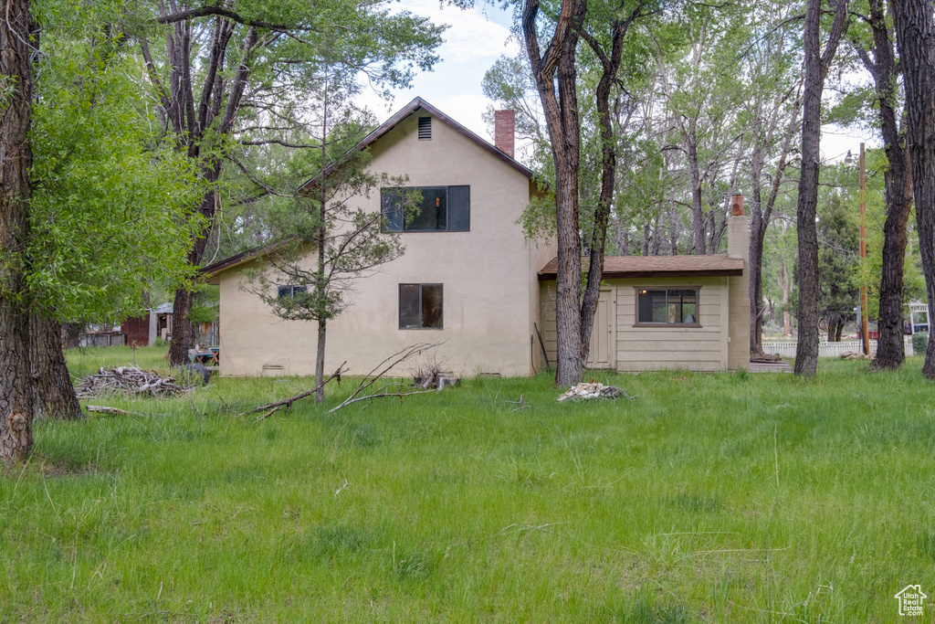 Back of property with a chimney and stucco siding