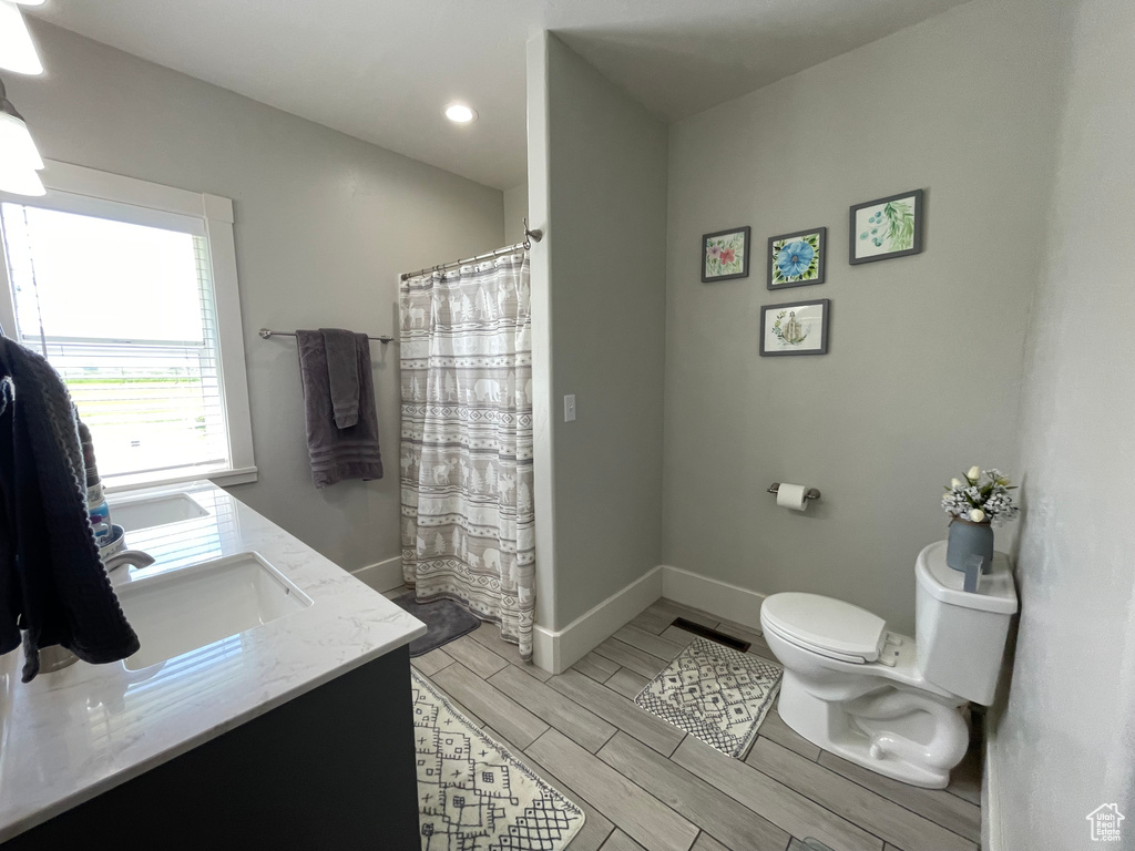 Full bathroom with double vanity, recessed lighting, wood finish floors, and a shower with shower curtain
