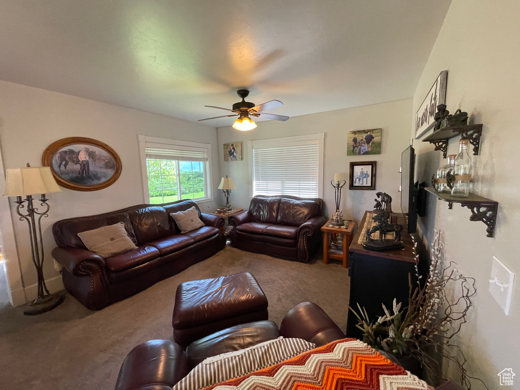 Carpeted living room with a ceiling fan