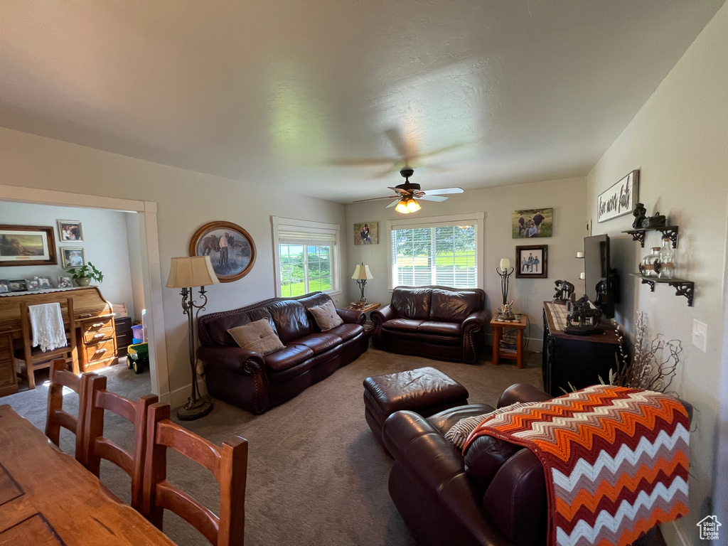 Carpeted living area with a ceiling fan