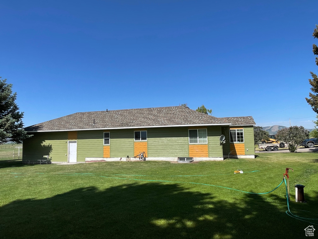 Rear view of house featuring a yard and a mountain view