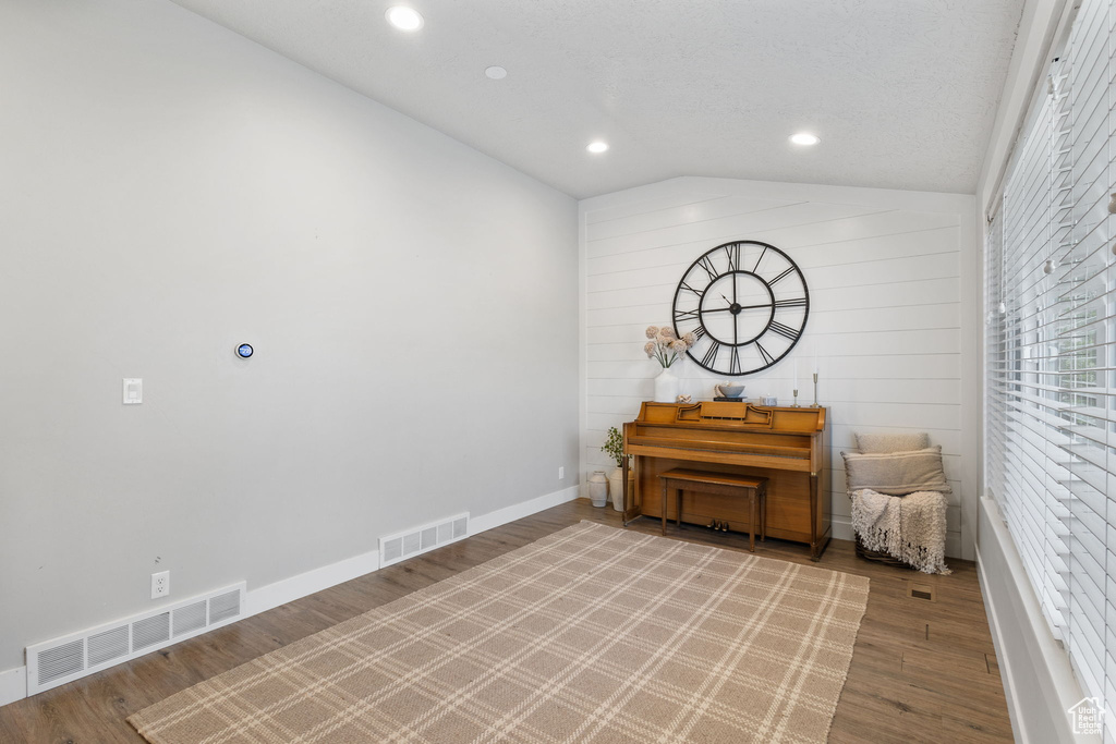 Living area with lofted ceiling, wood finished floors, and recessed lighting