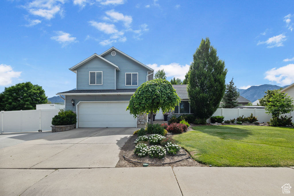 View of front of property featuring an attached garage, driveway, and stone siding
