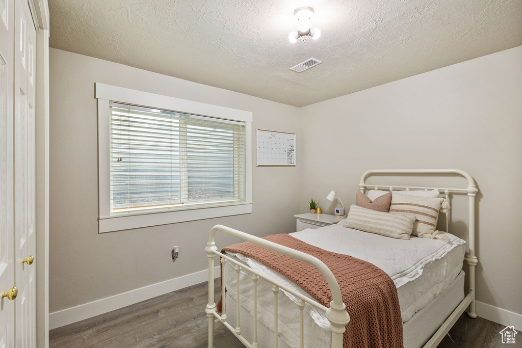 Bedroom with wood finished floors and baseboards