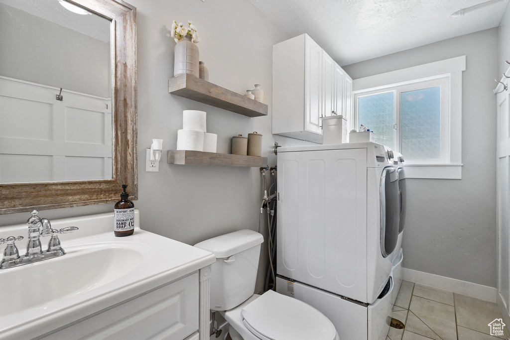 Bathroom featuring washer / dryer, vanity, and tile patterned floors