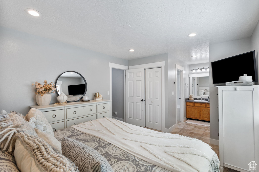 Bedroom with ensuite bath, a closet, and recessed lighting
