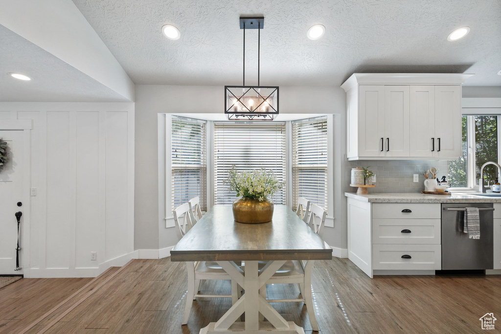 Dining space featuring light wood finished floors, recessed lighting, and a textured ceiling