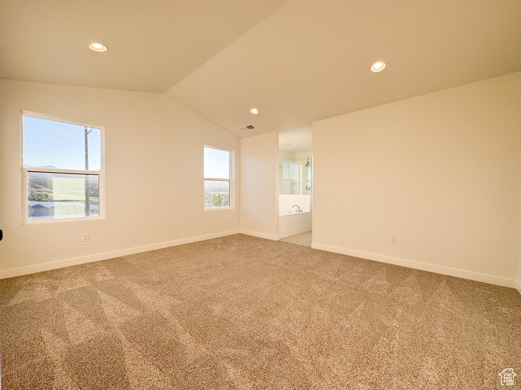 Empty room with carpet flooring, vaulted ceiling, and recessed lighting