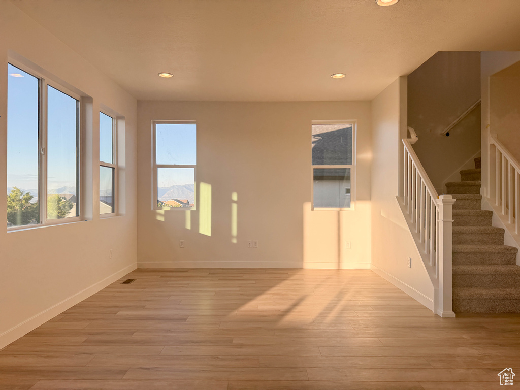 Unfurnished room with stairs, light wood finished floors, and recessed lighting