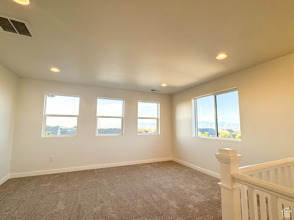 Carpeted empty room with recessed lighting