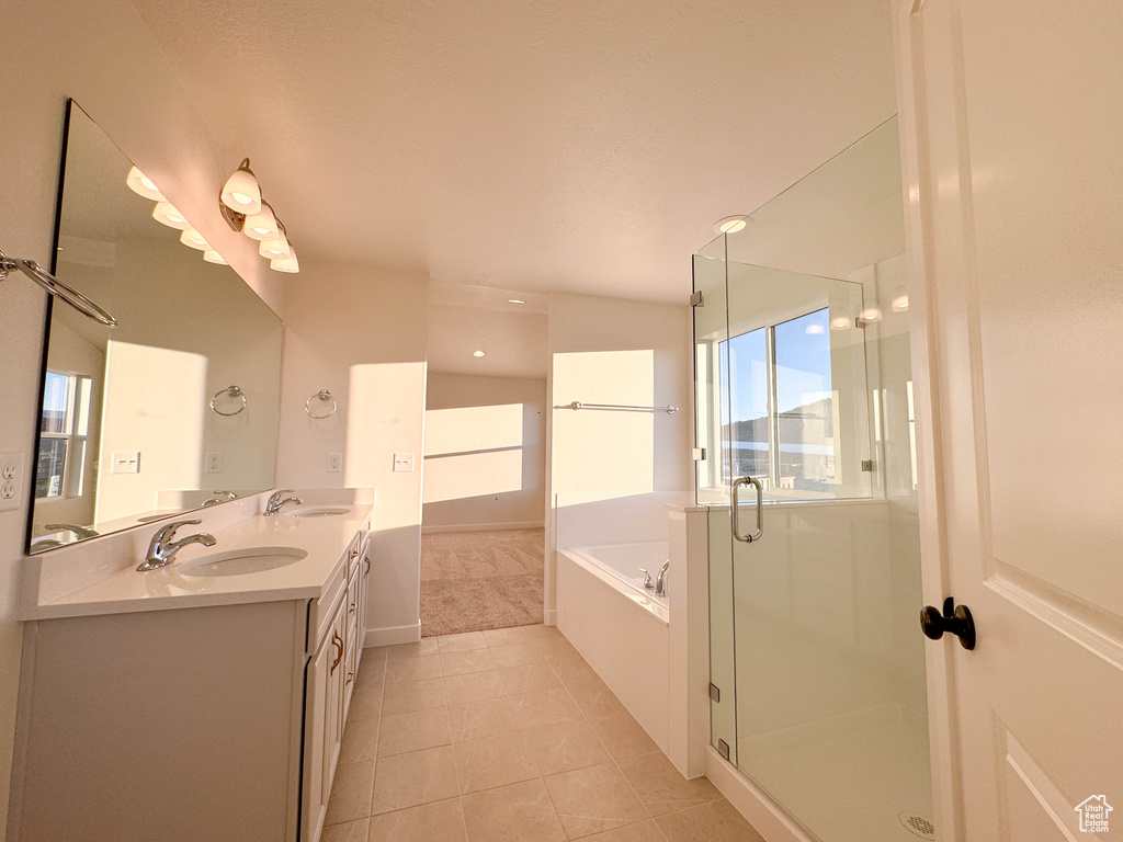 Bathroom featuring a bath, double vanity, tile patterned flooring, and a stall shower